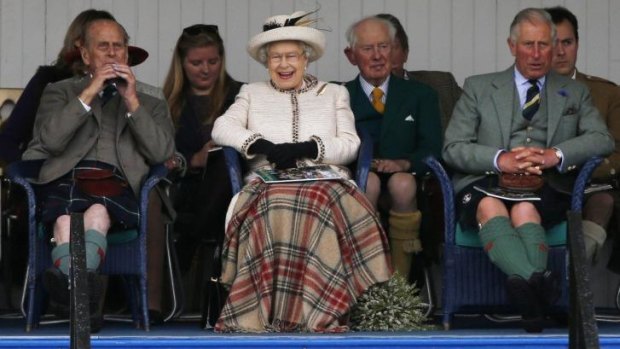Queen Elizabeth, Prince Philip (left) and Prince Charles watch the caber being tossed at the annual Braemar Highland Gathering in Braemar on the weekend.