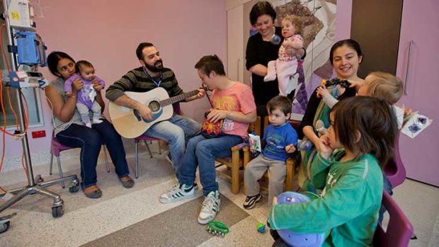 Rodrigo Quiroga playing guitar with patients at a children’s hospital