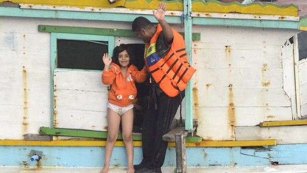 Officers on a boat that had been missing offload people at Christmas Island.