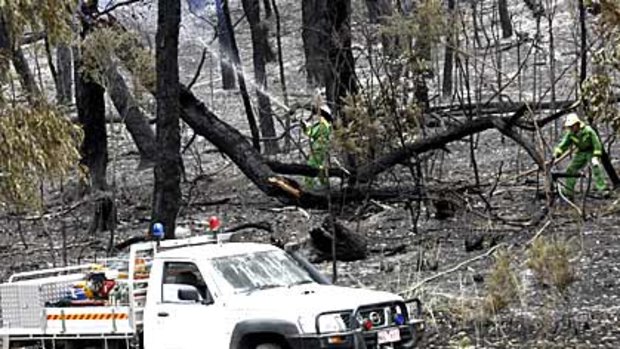 Firefighers mop up at Boolarra, where a bushfire has destroyed at least 29 homes.