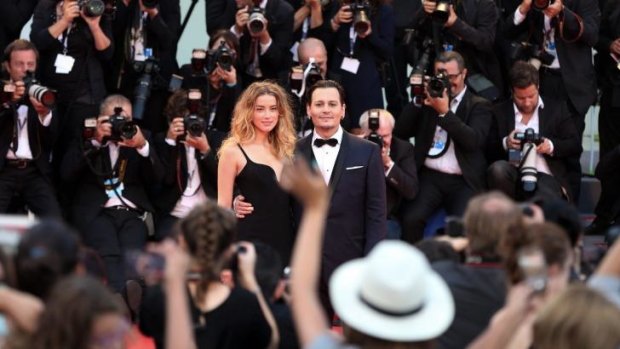 Amber Heard and Johnny Depp pose upon arrival at the premiere of <i>Black Mass</i> at the 72nd Venice Film Festival.