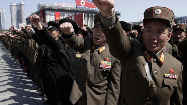 North Korean army officers punch the air as they chant slogans during a rally.