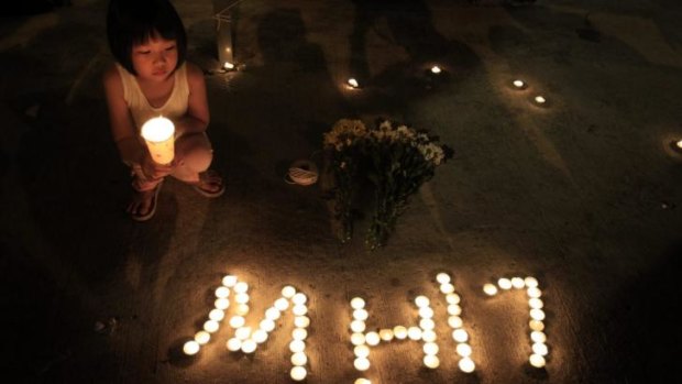 A little girl pays her respects during an event to mourn the victims of MH17 in Kuala Lumpur.