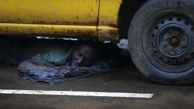 A Liberian man is put under detention and made to lie under a car after showing Ebola symptoms.
