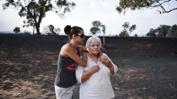 Ruth White gains support from her granddaughter, Amber Manicaros, after returning to Uarbry on Monday to find their home destroyed.