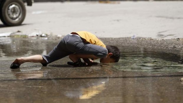 Thirst quencher: A boy drinks water from a burst water pipe in the Karm al-Jabal district of Aleppo, in northern Syria.