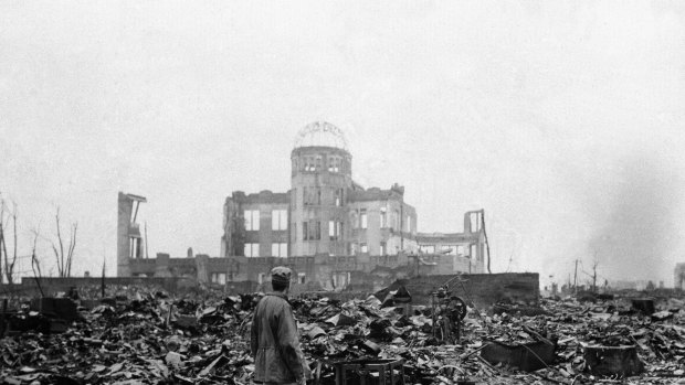 An Allied correspondent stands in the rubble of a building that once was a movie theatre in Hiroshima, on Sepember 8, 1945, after the first nuclear weapon ever used in warfare was dropped by the US on August 6, 1945.