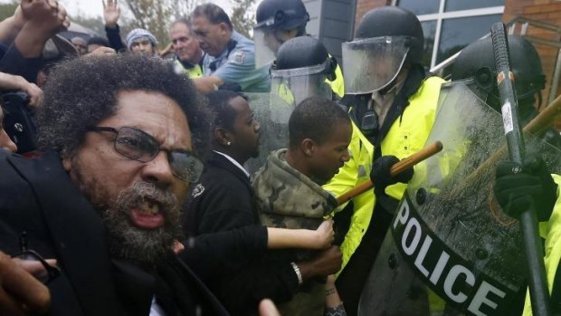 Unrest continues: Activist Cornel West is knocked over during a scuffle with police during a protest at the Ferguson Police Department.