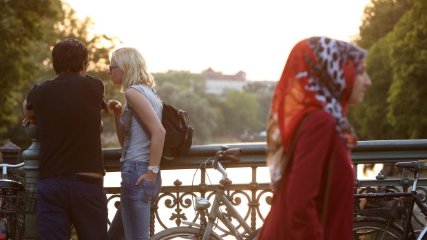 Visitors mingle along the Landwehrkanal in the Kreuzberg district of Berlin.