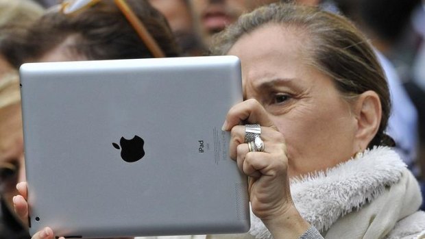 A woman uses an Apple iPad to photograph the street parade at the annual Notting Hill Carnival in central London August 29, 2011.