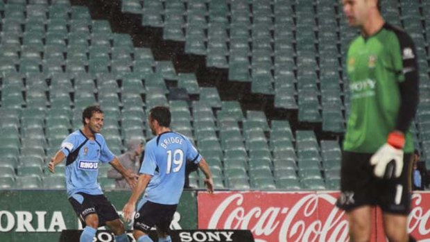 Lonesome Blues ... Mark Bridge and Alex Brosque celebrate a Sydney goal, but no one was watching on Wednesday.