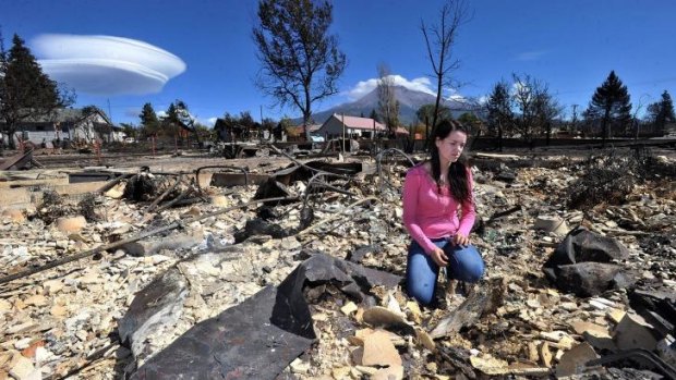 Taylor Yoakum, 19, looks for family heirlooms in her destroyed home in Weed, California.