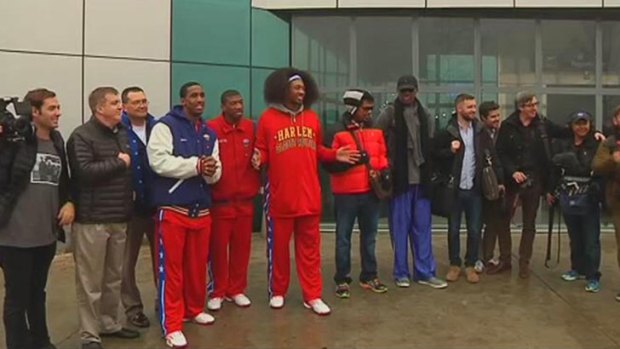 Retired NBA basketball player Dennis Rodman poses with his team members after arriving in Pyongyang.