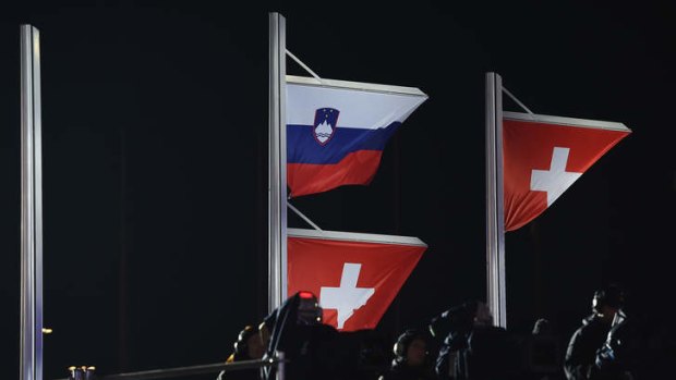 True colours: A Slovenian and a Swiss flag are raised on the same flagpole for joint gold medalists Tina Maze of Slovenia and Dominique Gisin of Switzerland.