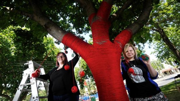 Renee and Bali of the Yarncorner collective decorate trees on Rathdowne Street, Carlton, for Yarra Council.