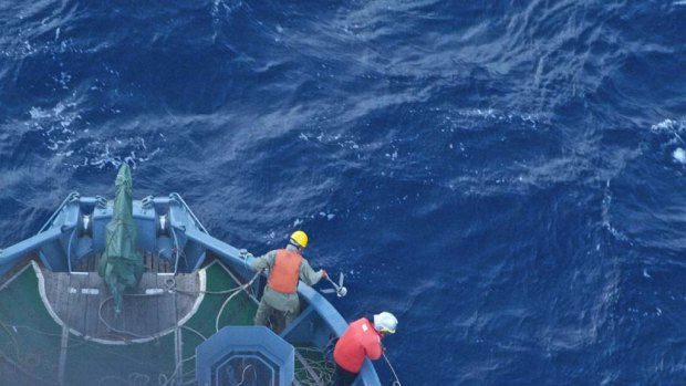 Yushin Maru No.2 crew members drop a grappling hook on Sea Shepherd boats.