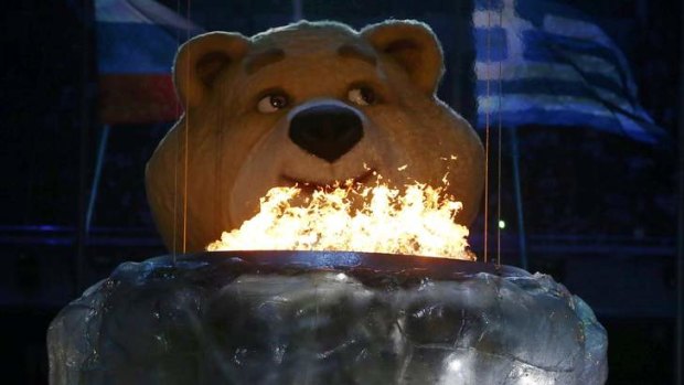 A robotic bear pauses before extinguishing the Olympic flame.