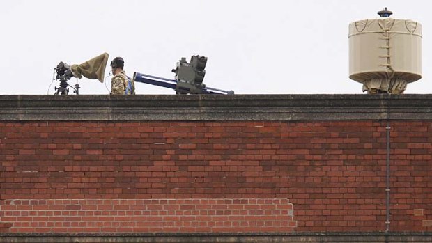 A member of the armed forces stands on duty next to an anti-aircraft missile battery overlooking the Olympic Park in Stratford.