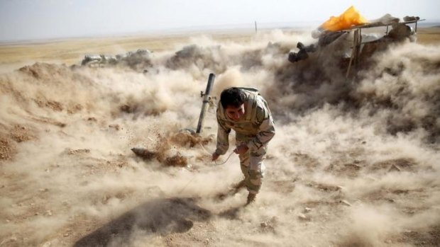 A Kurdish Peshmerga fighter launches mortar shells.