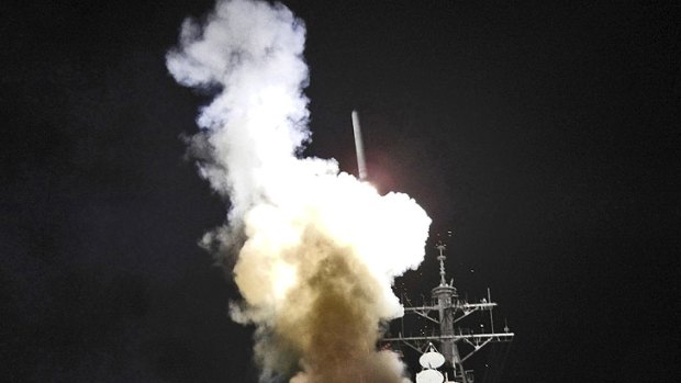 The guided-missile destroyer USS Barry launches a Tomahawk missile from the Mediterranean Sea in a joint US and British attack on radar and anti-aircraft sites.