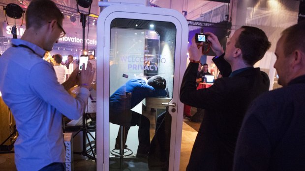 An attendee takes a nap in a privacy booth at Slush 2016.