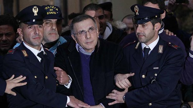 Italian officers lead Michele Zagaria from a police station.
