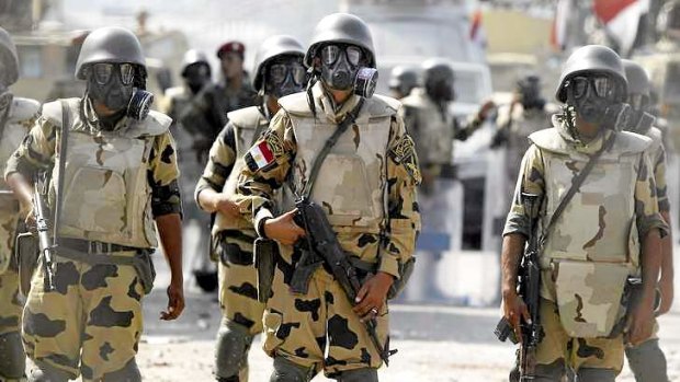 Army soldiers wear gas masks before clashes with members of the Muslim Brotherhood and supporters of deposed Egyptian President Mohamed Mursi at Republican Guard headquarters in Nasr City, a suburb of Cairo.