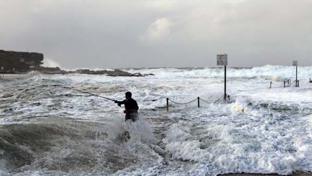 A little wet around the ankles... a fisherman tries his luck at Clovelly yesterday.