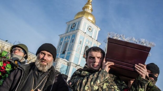 Men carry a casket containing the body of an anti-government protester killed in clashes with police in Kiev.
