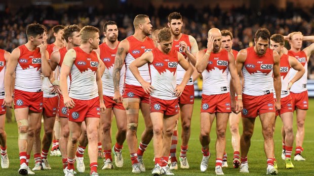 Down and out: Swans leave the ground after second semi-final loss to the Cats.