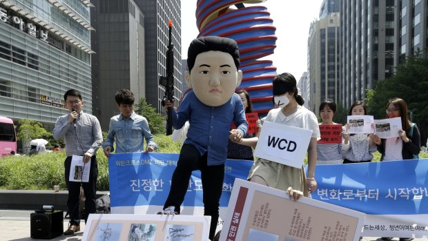 A South Korean university student, centre left, wearing a mask of North Korean leader Kim Jong Un performs with his fellow student symbolising the women activists of WCD, Women Cross DMZ, during a gathering to oppose the group's plans to march from North Korea to South Korea.
