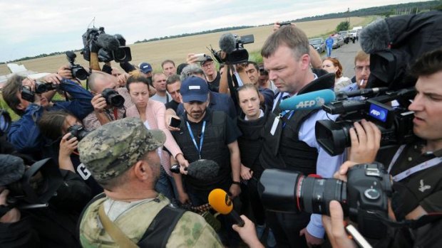 Alexander Hug, (right) Deputy Chief Monitor of the Organisation for Cooperation and Security in Europe's (OSCE) Special Monitoring Mission to Ukraine speaks to the press at the crash site.