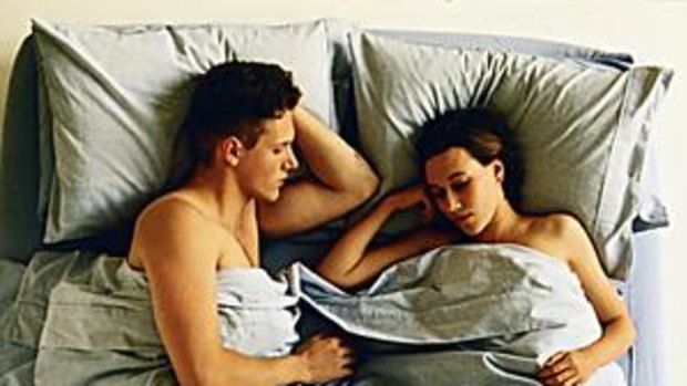 A man and woman sleeping in bed.