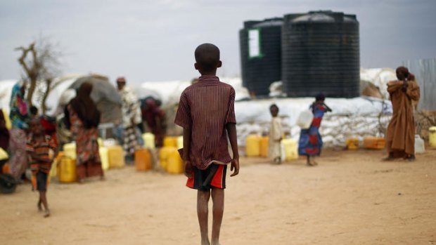 A boy waits to collect water at the Dadaab camp.