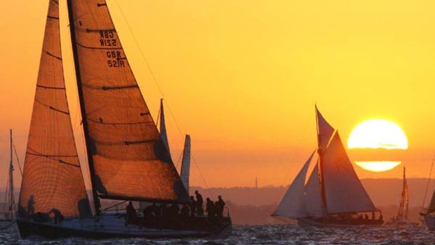 The sun rises at the 5am start of the JP Morgan Asset Management Round the Island Race, with The yacht "Bob" owned by BP Chief Executive Tony Hayward, left.