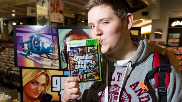 Taylor Pelling poses with his copy of Grand Theft Auto V at the midnight opening of HMV in London.