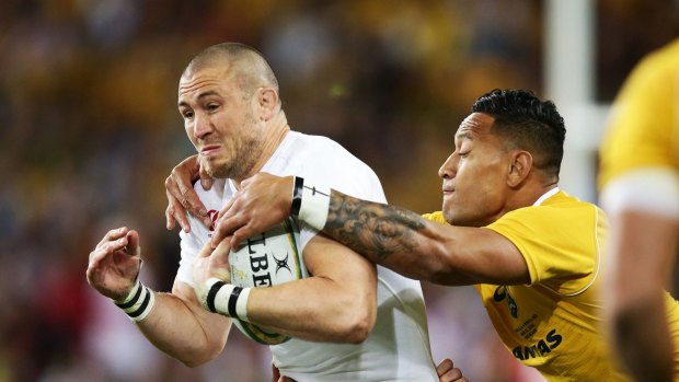 Slippery customer: Mike Brown tries to escape the clutches of Israel Folau.