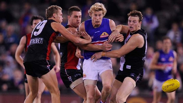 Held back: Western Bulldogs' Ed Barlow is held off the ball by St Kilda's Sam Gilbert, left, Sam Fisher and Brendon Goddard, right.