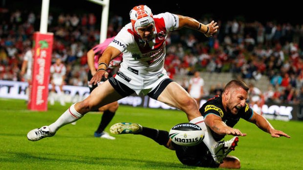 Jamie Soward of the Dragons shields the ball from Lewis Brown of the Panthers.