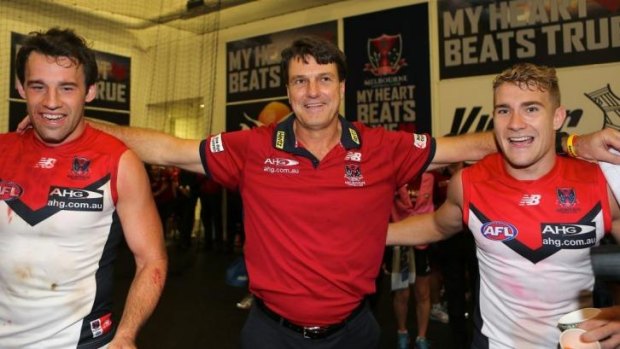 Melbourne coach Paul Roos joins in the team song after his first win as Demons coach on Saturday. 