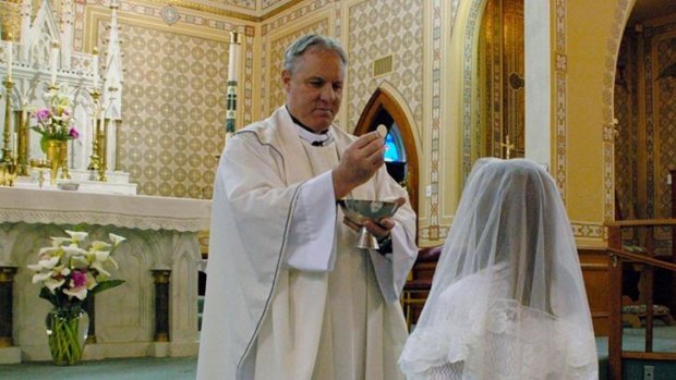 Much loved ... This May 2012 photo, provided by Lynn Enemark, shows the Reverend Eric Freed administering First Communion in St. Bernard Catholic Church in Eureka, California.