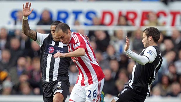 Newcastle United's Danny Simpson (left) and Yohan Cabaye (right) vie for the ball with Stoke City's Matthew Etherington.