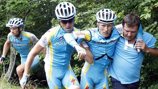 Astana rider Alexandre Vinokourov of Kazakhstan is carried by teammates out of the bushes after crashing out of the Tour de France.