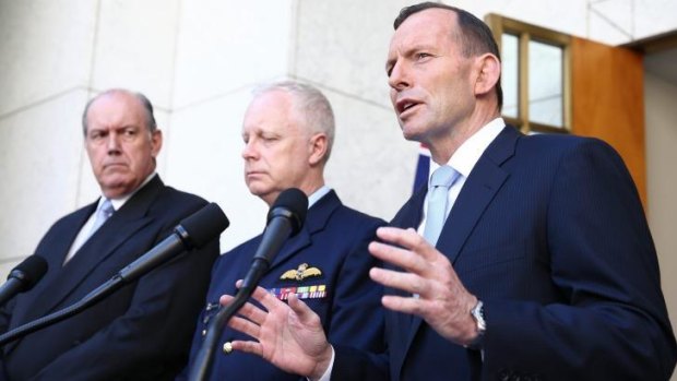 Prime Minister Tony Abbott, with Defence Minister David Johnston and chief of the Defence Force Air Chief Marshal Mark Binskin, announces the security committee's decision.