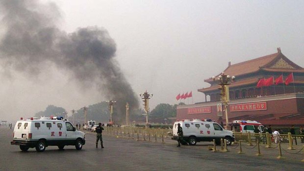 Police cars block off the roads leading into Tiananmen Square as smoke rises into the air after a vehicle crashed in front of Tiananmen Gate on Monday.