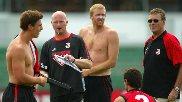 Dean Wallis, (second from left), in a previous incarnation as an Essendon assistant coach, under Kevin Sheedy.