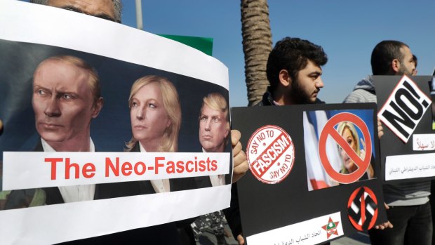 A Lebanese communist protester holds a placard protesting against Le Pen's visit, in Beirut, Lebanon. 