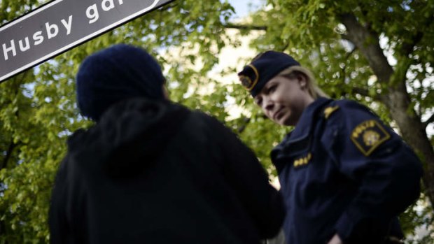 Stockholm riots: A policewoman speaks to a resident of Husby.