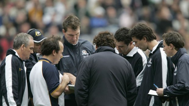 Jim Stynes, centre, speaks with Australian coach Gary Lyon (third from right) and the rest of the team's coaching staff during the 2004 international rules series.