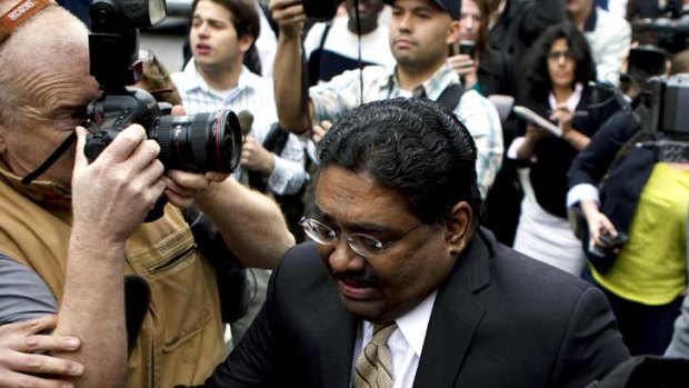 Disgraced hedge fund manager Raj Rajaratnam fights through the media outside his court hearing in the US.